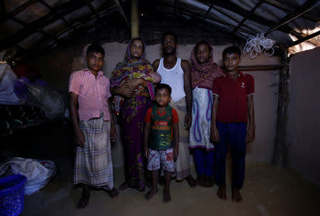 Mohammad Zubair (L), 14, a Rohingya refugee boy, poses for a picture along with his mother Fatima Begum (2nd L), Father Nur Kobir (3rd R), sister Anu Ara (2nd R), brother Mohammad Harris (R) and brother Mohammad Zasangir (C) inside their temporary shelter at Kutupalong refugee camp near Cox's Bazar, Bangladesh, November 12, 2017. REUTERS/Navesh Chitrakar
