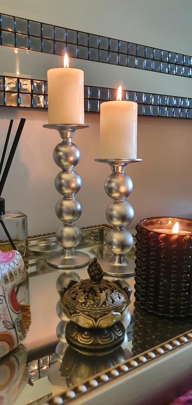 A pair of silver candle holders made out of table tennis balls and silver spray paint