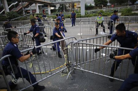 Police remove barricades erected by pro-democracy protesters at the main protest site in Admiralty in Hong Kong in this October 13, 2014 file photo. REUTERS/Carlos Barria/Files
