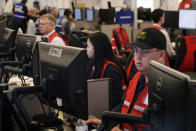 FILE - In this Oct. 10, 2019, file photo, Pacific Gas & Electric employees work in the PG&E Emergency Operations Center in San Francisco. California's utility regulator is issuing a series of sanctions against Pacific Gas and Electric for what it calls "failures in execution" during the largest planned power shut-off in state history to avoid wildfires. (AP Photo/Jeff Chiu, File)