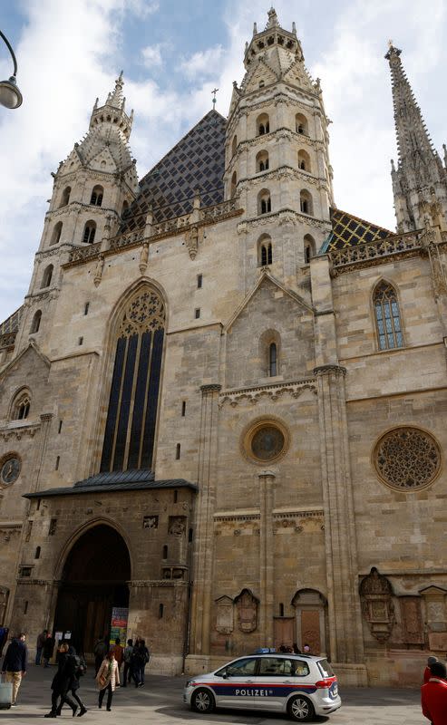 An Austrian police car passes St. Stephens cathedral in Vienna