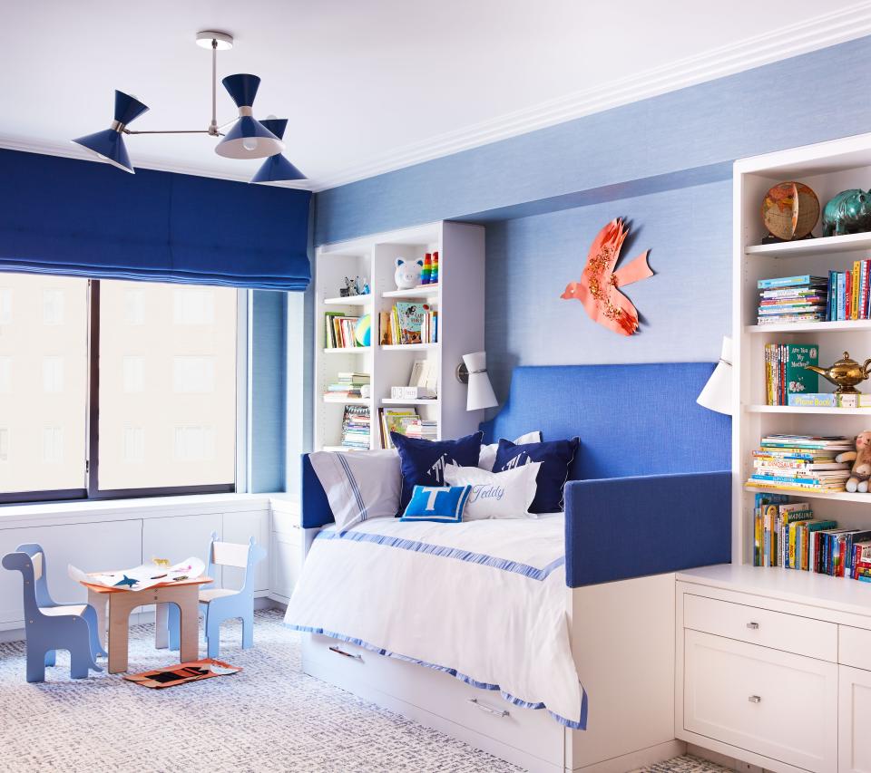 In one of the kids’ rooms, the custom bed, with headboard and rails in Manuel Canovas fabric, is a trundle for sleepovers. The Roman shade is in the same Canovas fabric. Wool carpet is by Patterson Flynn Martin, and bedding is by Matouk. A geometric ’50s-style enamel chandelier is by Blueprint Lighting. The diminutive table and chairs are by Piggl.