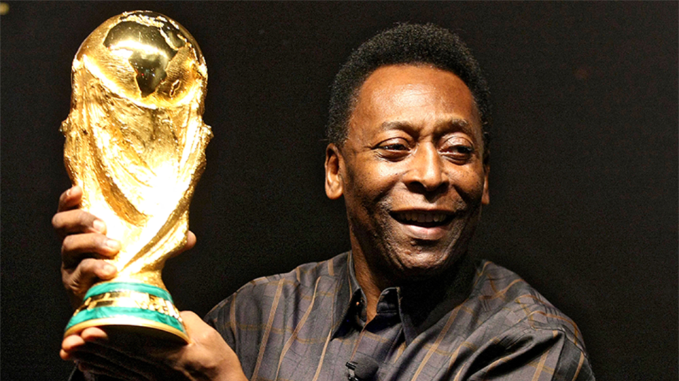 Brazil and football icon Pele holding the World Cup trophy.