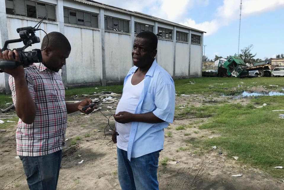 Beira Mayor Daviz Simango, right, pauses from directing disaster relief operations in Beira, Mozambique, Monday March 25, 2019. Simango dreamed about protecting his people from climate change with much of the city being below sea level on a coastline that experts call one of the world's most vulnerable to global warming's rising waters. (AP Photo/Cara Anna)