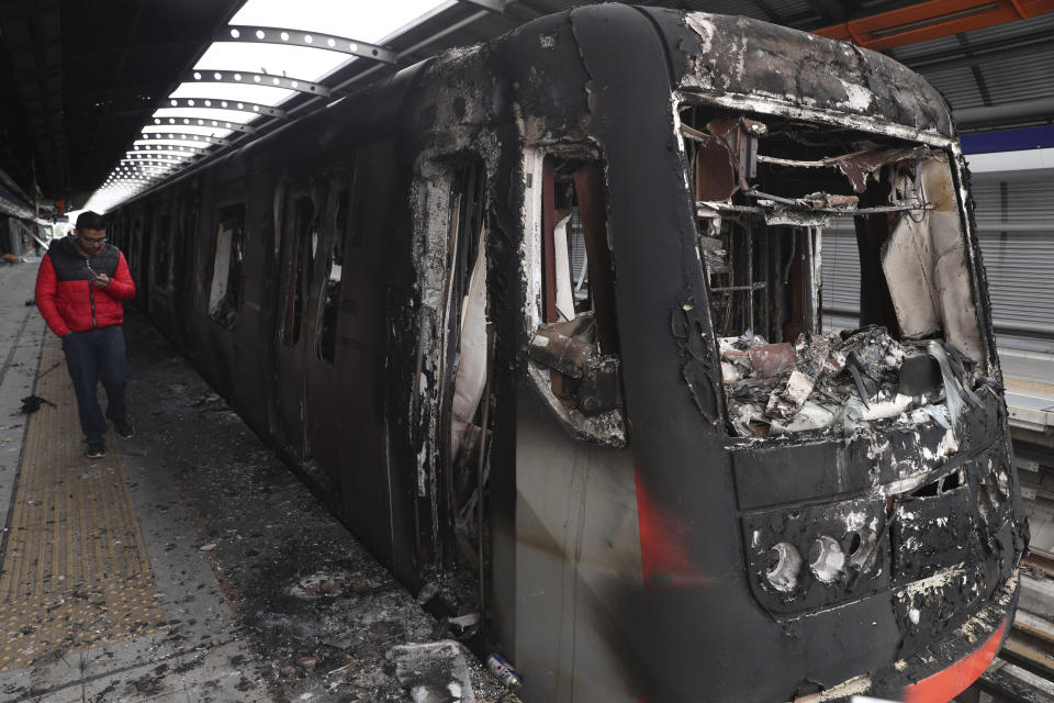 Subway cars burnt by protesters are parked at the Elisa Correa station in Santiago, Chile, Sunday, Oct. 20, 2019. Chilean President Sebastián Piñera on Saturday announced the suspension of a subway fare hike that had prompted violent student protests, less than a day after he declared a state of emergency amid rioting and commuter chaos in the capital. (AP Photo/Esteban Felix)