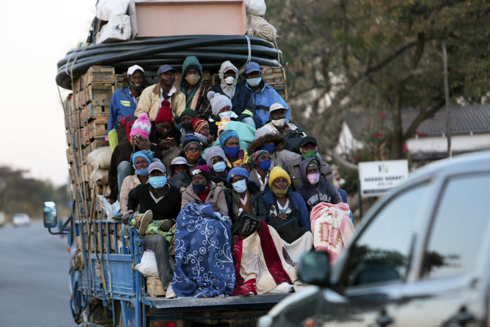 FILE - In this July, 22, 2020, file photo, an open truck carries farmers wearing face masks on the first day of the curfew in Harare, Wednesday, July, 22, 2020. Africa’s confirmed coronavirus cases have surpassed 1 million, but global health experts tell The Associated Press the true toll is several times higher. (AP Photo/Tsvangirayi Mukwazhi, File)