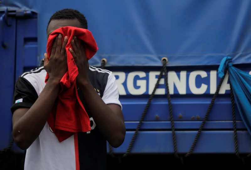 A migrant covers his face as migrants, which are stranded in Honduras after borders were closed due to the coronavirus disease (COVID-19) outbreak, rest while trekking northward in an attempt to reach the United States, in Choluteca