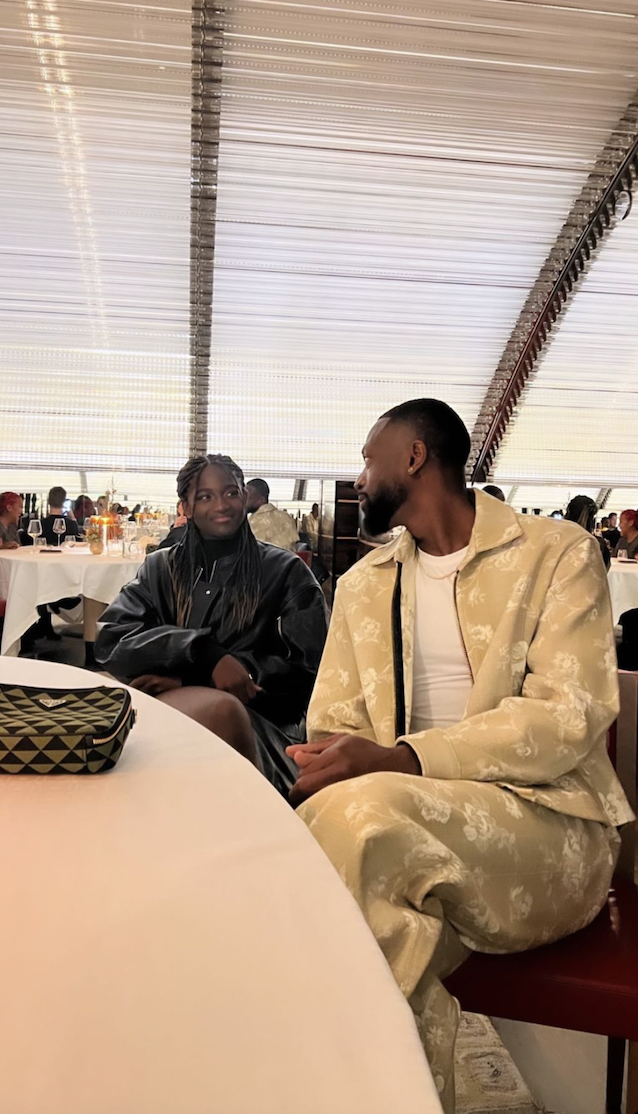 Dwyane Wade and Zaya sitting at a table