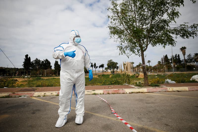 A paramedic wearing a protective suit stands near a special polling station set up by Israel's election committee so Israelis under home-quarantine can vote in Israel's national election, in Ashkelon, Israel