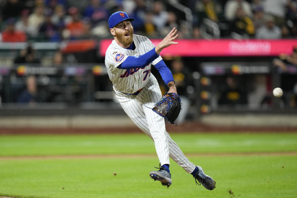 New York Mets pitcher Reed Garrett tries to get the ball to first base but commits a throwing error during the seventh inning of a baseball game against the Pittsburgh Pirates at Citi Field, Tuesday, April 16, 2024, in New York. (AP Photo/Seth Wenig)