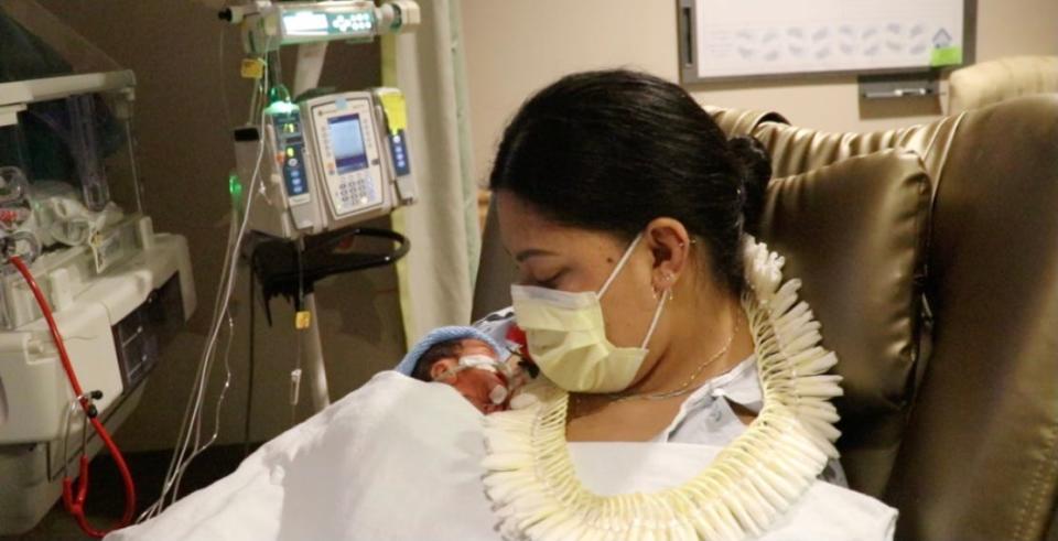 Lavinia Mounga holding her premature infant son, Raymond.