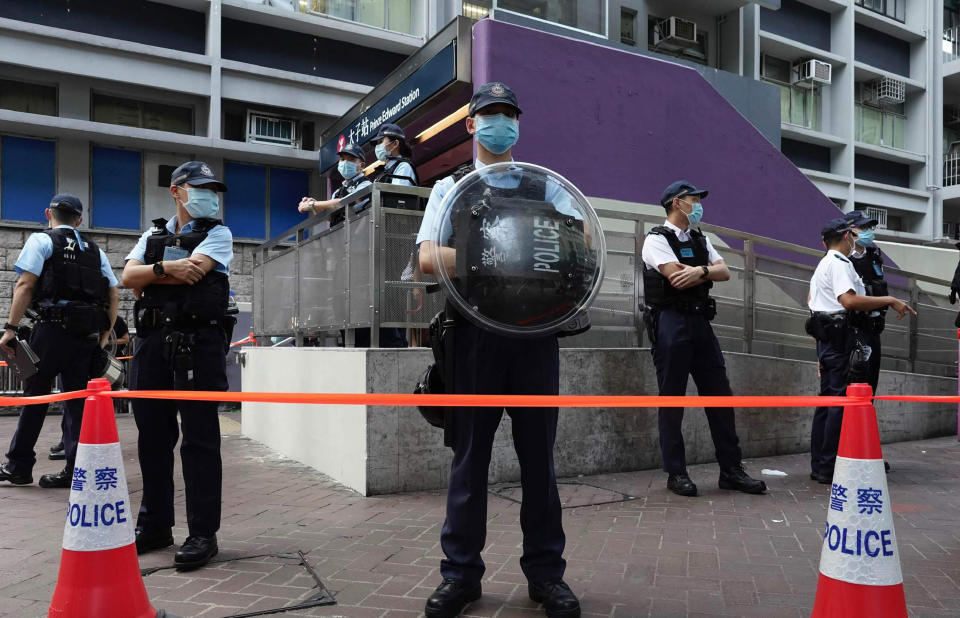 Police officers stand guard outside the Prince Edward subway station in Hong Kong Monday, Aug. 31, 2020. Aug. 31 is the first anniversary of police raid on Prince Edward subway station which resulted in widespread images of police beating people and drenching them with pepper spray in subway carriages. (AP Photo/Vincent Yu)