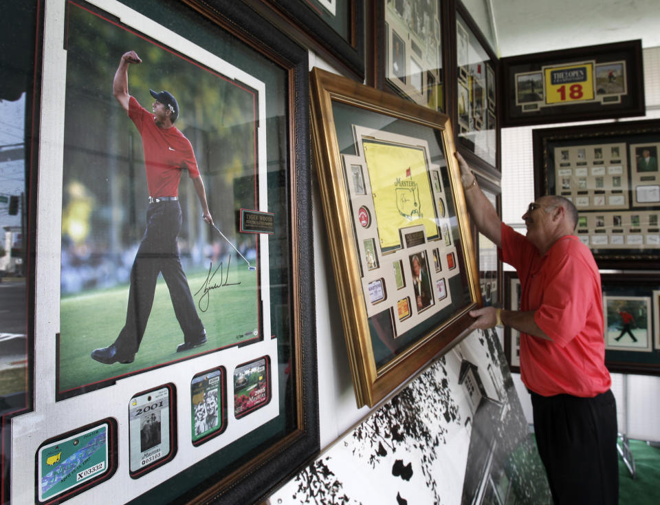 FILE - In this April 8, 2010, file photo, vendor Roger E. Gilchrist hangs memorabilia for sale in his tent outside the gates of the Augusta National Golf Club, the site of the Masters golf tournament in Augusta, Ga. The Masters is so intertwined with Augusta, they added an extra day to spring break. You see, the first full week of April isn't just a blip in time for this place. It's their identity, their way of life, their golf-cart path to success. (AP Photo/Rob Carr, File)