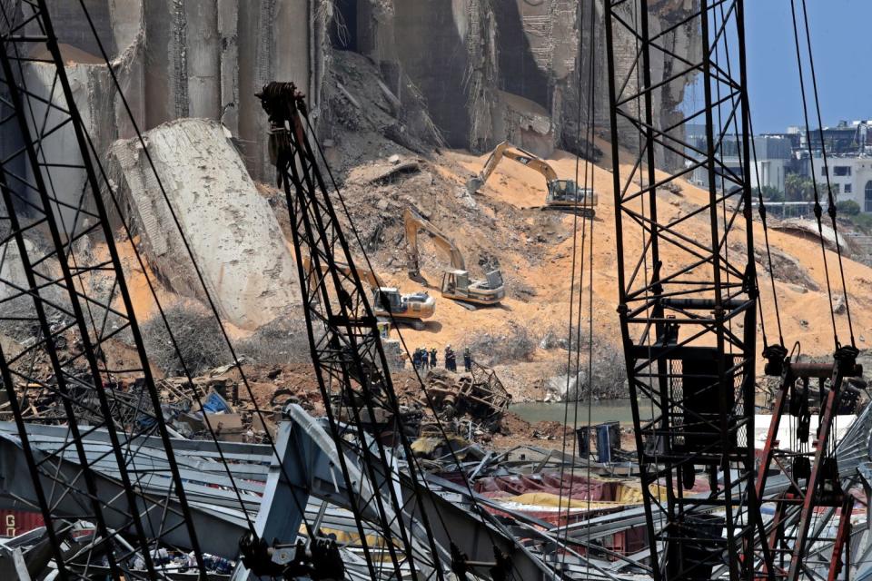 Rescuers use excavators to clear rubble at site of damaged grain silos in Beirut