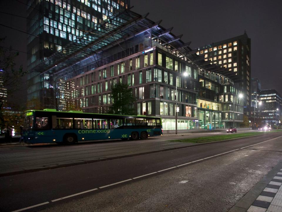 Commuters wait for public transport at a bus stop at Zuidas office district in Amsterdam, Netherlands, Monday, Nov. 19, 2012. ()