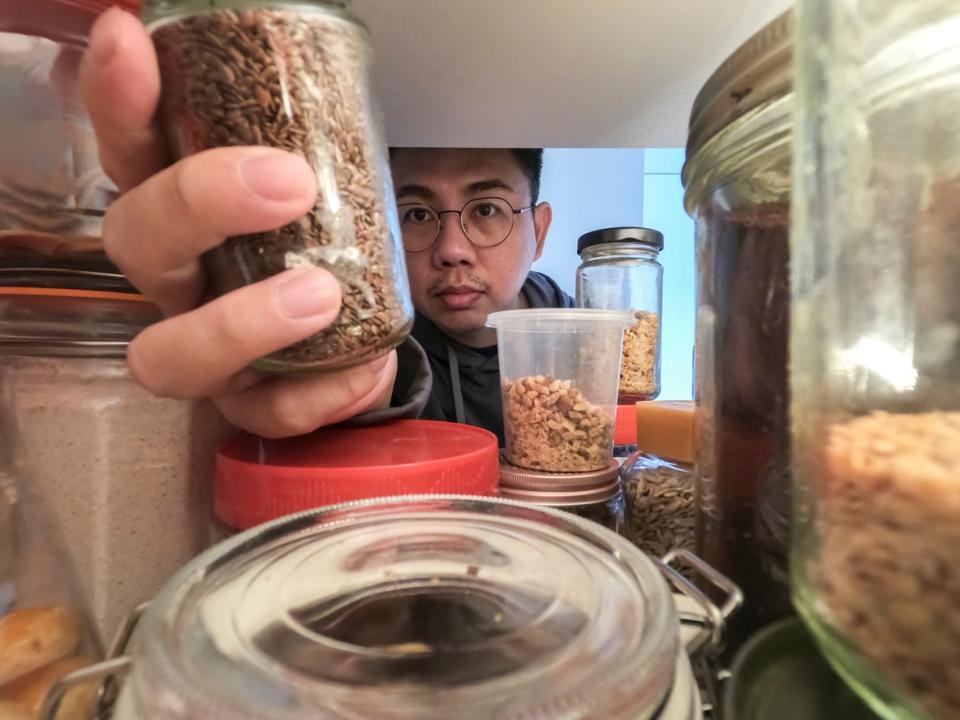 Man reaching for something in the back of the refrigerator