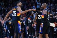 Phoenix Suns forward Mikal Bridges (25) celebrates with guard Chris Paul (3) during the second half of an NBA basketball game against the Golden State Warriors, Tuesday, Nov. 30, 2021, in Phoenix. The Suns won 104-96. (AP Photo/Matt York)