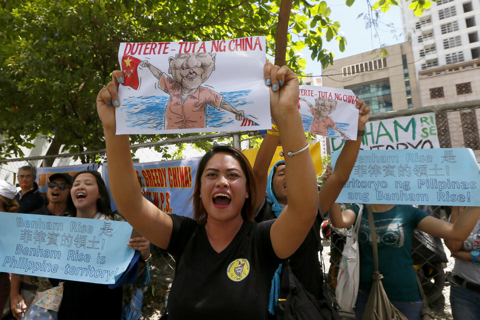 FILE - In this March 24, 2017, file photo, protesters shout slogans while displaying placards in front of the Chinese Consulate to protest China's alleged continuing "militarization" of the disputed islands off the South China Sea, including a plan to build a monitoring station on Scarborough Shoal in Makati city, east of Manila, Philippines. The Philippine government filed a diplomatic protest after Chinese forces seized fishing equipment set up by Filipinos in a disputed shoal in their latest territorial spat in the South China Sea. The Department of Foreign Affairs in Manila said in a statement Thursday night, Aug. 20,. 2020 that the Philippines “also resolutely objected" to China continuing to issue radio challenges to Philippine aircraft patrolling over the disputed waters. (AP Photo/Bullit Marquez, File)