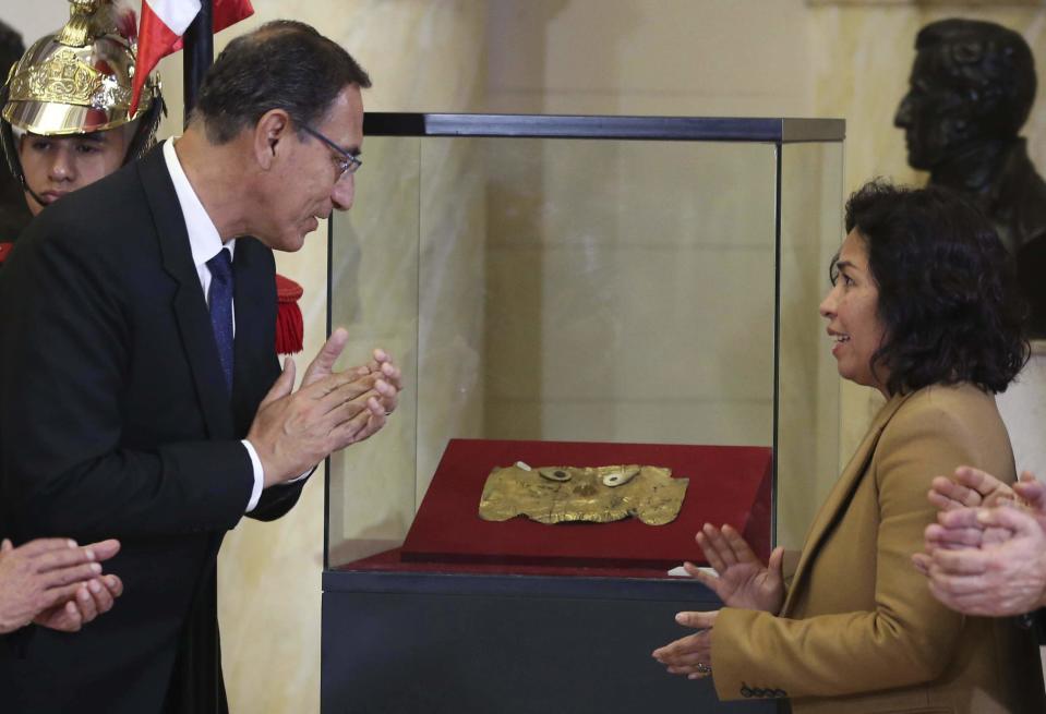 Peru's President Martin Vizcarra, left, and Culture Minister Patricia Balbuena, celebrate the return of the pre-Columbian gold funerary Sican mask, that disappeared in 1999 and was recovered by Interpol in Germany, in Lima, Peru, Monday, Sept. 10, 2018. Germany returned the mask to Peru following a 20-year legal and diplomatic battle, after Peru had reported the eighth century mask’s disappearance in 1999. (AP Photo/Martin Mejia)