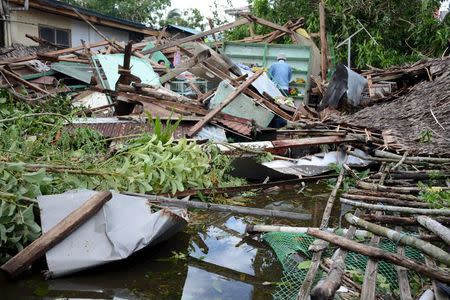 Residents sift through the ruins of their houses after strong winds and heavy rains brought by typhoon Melor battered Barcelona town, Sorsogon province, central Philippines December 15, 2015. REUTERS/Renelyn Loquinario