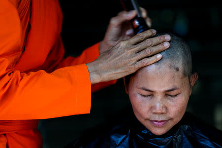 A devotee has her hair cut by a female buddhist monk during a mass female Buddhist novice monk ordination ceremony at the Songdhammakalyani monastery, Nakhon Pathom province, Thailand, December 5, 2018. REUTERS/Athit Perawongmetha