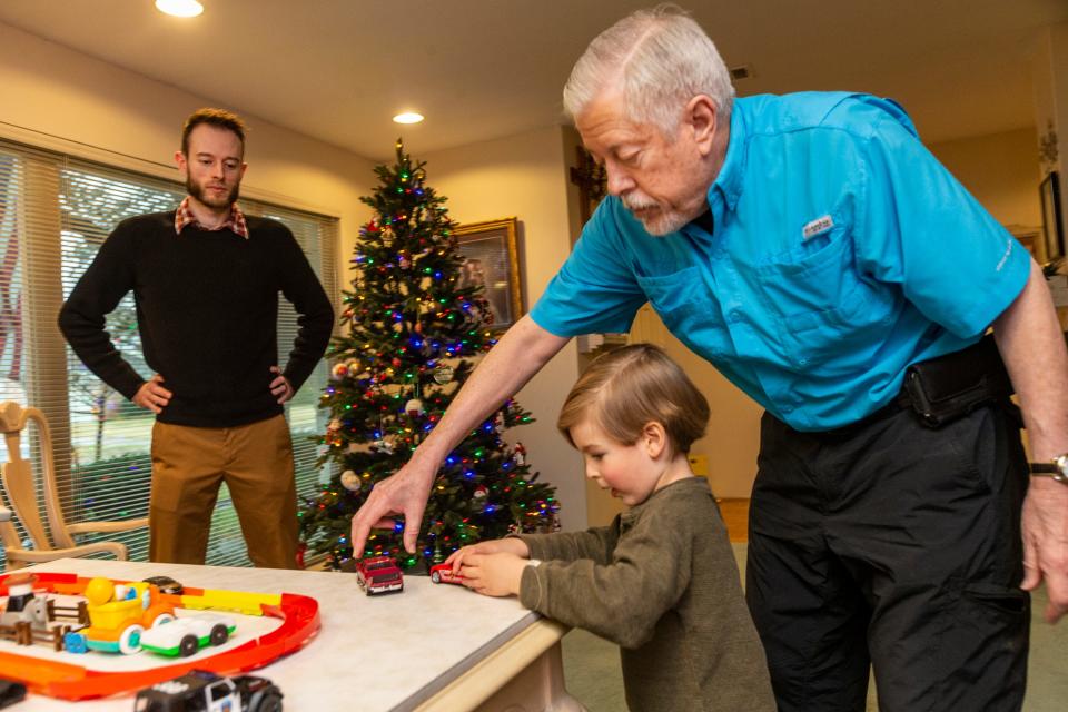 For a story on parents trying to keep grandparents holiday spending in check, we photograph, Andrew Herzog (black sweater), his father Chris Herzog (Blue Shirt), and son Patrick (3 years old). Grandfather Chris often babysits Patrick..Photos taken at the home of grandfather, Chris Herzog, who resides in Dallas, Texas. The three were playing with some transportation themed toys on the dining room table which became an imaginary race track.