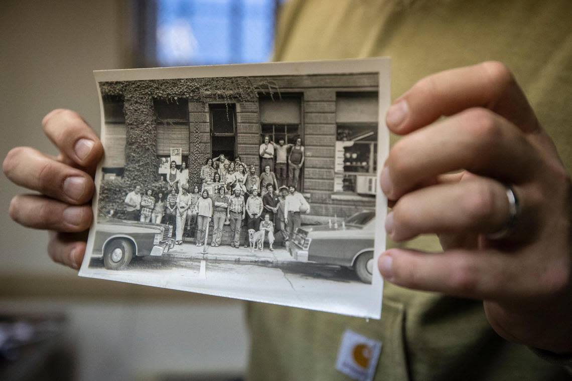 Appalshop Operations Director Roger May holds a photograph of previous staff. The photo was recovered from the organization’s main building that was flooded last summer.