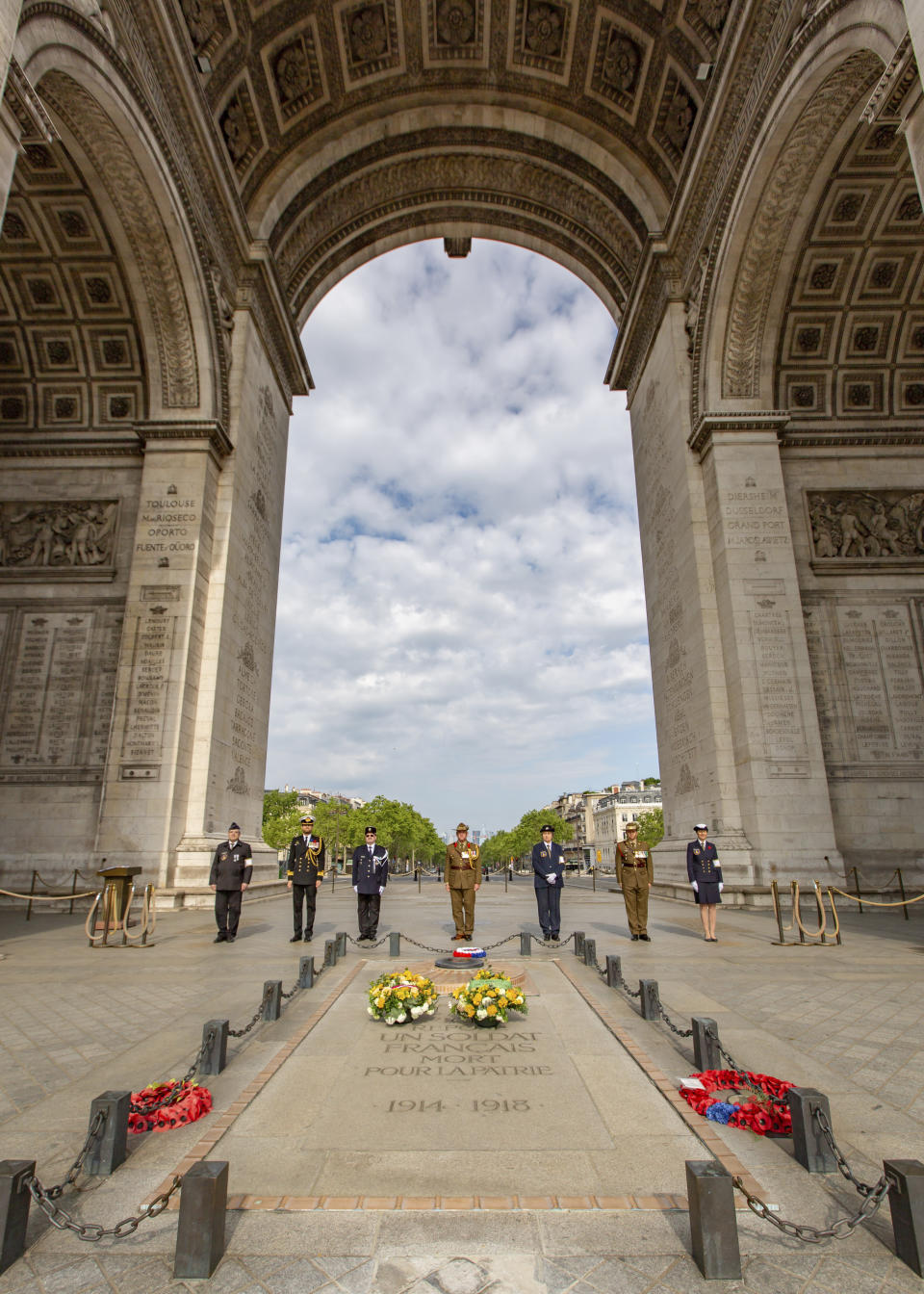 This photo provided by the Australian Embassy in Paris, shows Australian Defense Attache to France Colonel Joel Dooley and ADF members paying their respects at the tomb of the unknown soldier beneath the Arc de Triomphe in Paris, Saturday April 25, 2020, on the occasion of Anzac Day. With France in coronavirus lockdown, there were no crowds to mark ANZAC Day, a national day of remembrance in Australia and New Zealand for those who served in all wars. (Simon Patching/Australian Embassy in France via AP)