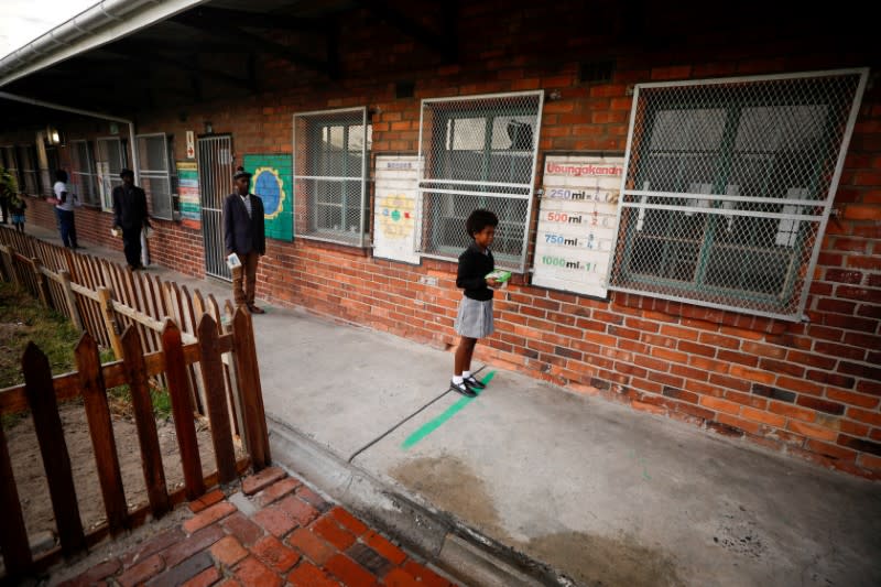 FILE PHOTO: Learners observe social distancing markers as they queue at a school feeding scheme in Gugulethu township during a nationwide lockdown aimed at limiting the spread of coronavirus disease (COVID-19) in Cape Town