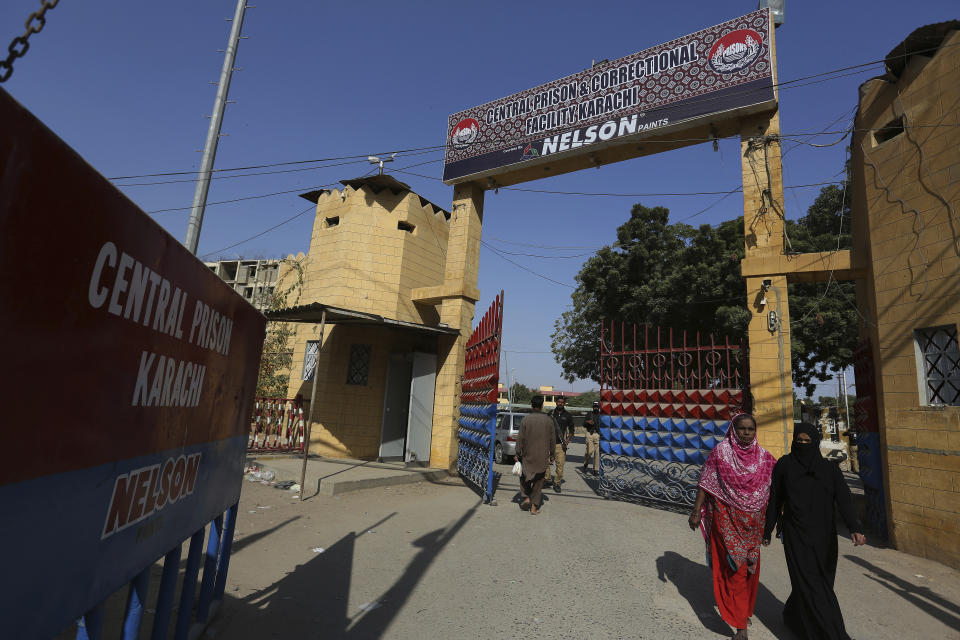 People walks on the main entrance of central prison where British-born Pakistani Ahmed Omar Saeed Sheikh, who is charged in the 2002 murder of American journalist Daniel Pearl, is detained, in Karachi, Pakistan, Thursday, Dec. 24, 2020. The provincial court overturned a Supreme Court Decision that Sheikh should remain in custody during an appeal of his acquittal on charges he murdered Pearl. (AP Photo/Fareed Khan)