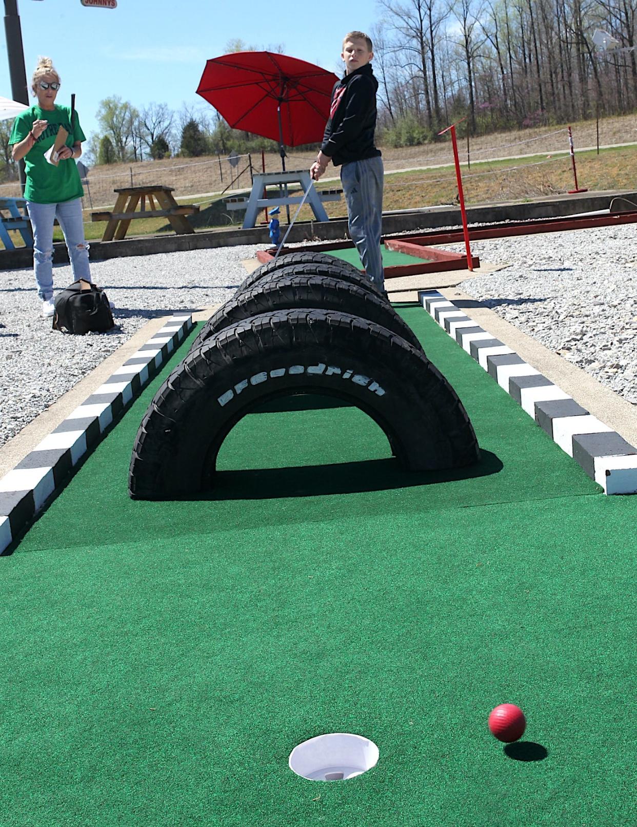 Braylen Harrison watches his shot as his mother Whitney Harrison looks on at Freedom Fairway on April 6, 2024.