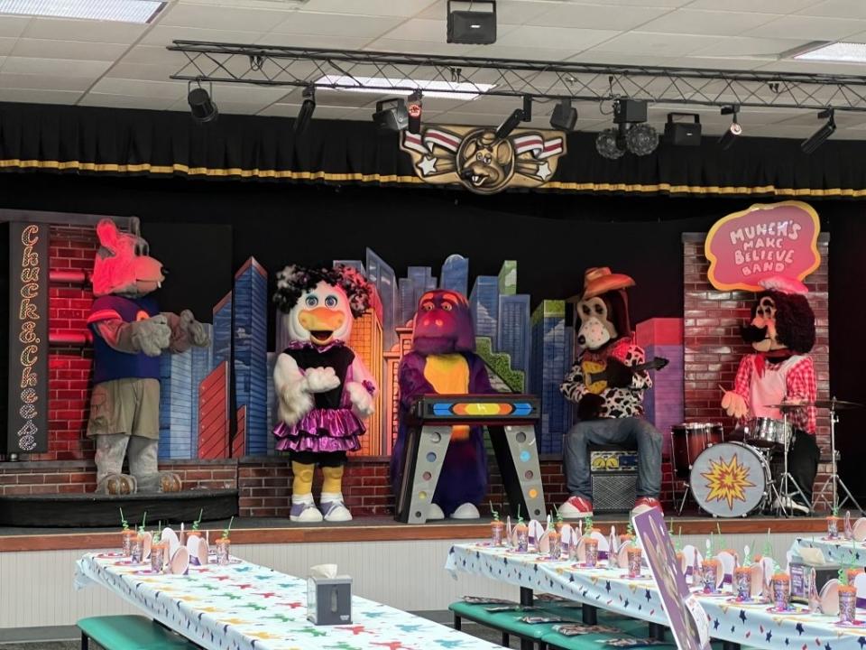 Animatronic band with wolf, cheerleader, gorilla, dog, and lion performing on stage at a family entertainment center