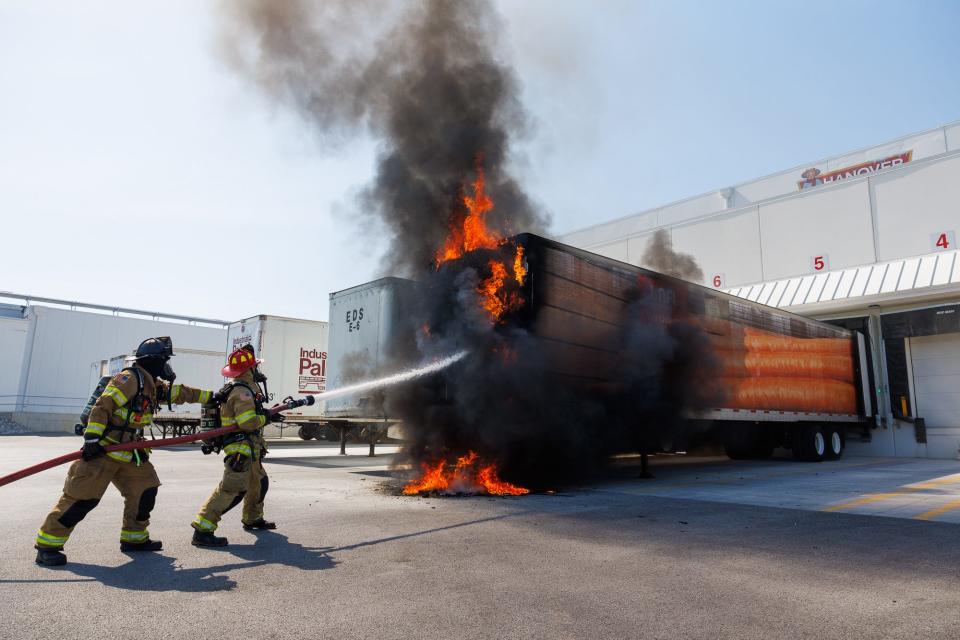 Hanover Area Fire & Rescue volunteer firefighter Tyler Wentz, left, and career firefighter Kory Weaver extinguish a trailer fire at the Hanover Foods Cold Storage facility on Wilson Avenue Monday.