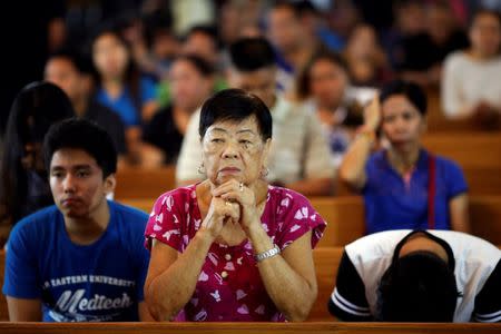 People pray during a service in a chapel at Camp Crame, the headquarters of Philippine National Police (PNP) in Manila, Philippines October 9, 2016. REUTERS/Damir Sagolj