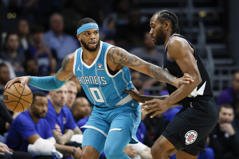 Charlotte Hornets forward Miles Bridges (0) runs the offense against Los Angeles Clippers forward Kawhi Leonard during the first half of an NBA basketball game in Charlotte, N.C., Sunday, March 31, 2024. (AP Photo/Nell Redmond)