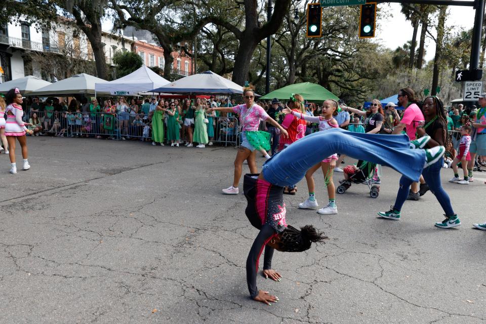 A parade participant goes head over heels along the parade route during the Savannah St. Patrick's Day Parade on Saturday, March 16, 2024.