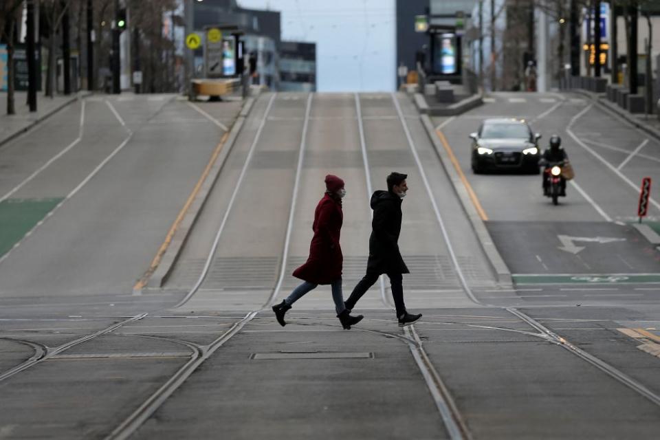 Pedestrians walk through the quiet streets of Melbourne.