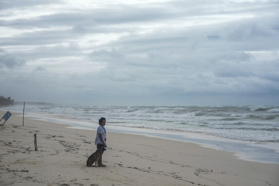 A man and his dog stand on the shore of a beach in the aftermath of Hurricane Beryl in Tulum, Mexico, Friday, July 5, 2024. (AP Photo/Fernando Llano)