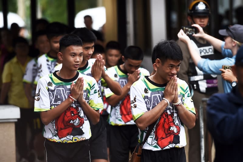 <p>Some of the twelve Thai boys, rescued from a flooded cave after being trapped, arrive to attend a press conference in Chiang Rai on July 18, 2018, following their discharge from the hospital. The young footballers and their coach appeared healthy when they appeared before the media for the first time on that day. (Photo from Lillian Suwanrumpha/AFP/Getty Images) </p>