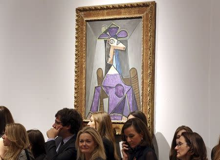 Christie's employees stand in front of an artwork titled "Portrait de femme (Dora Maar)" by artist Pablo Picasso during a Christie's auction in New York May 6, 2014. REUTERS/Adam Hunger