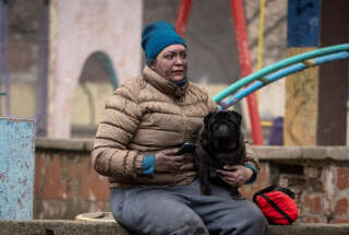 Le 7 février 2024 à Kiev (Ukraine). Une riveraine assise près de son immeuble touché par des missiles russes. . Photo Danylo Antoniuk/REUTERS