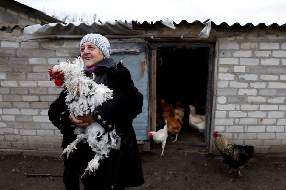 Farmer Yevheniia Andriivna, 70, who refuses to evacuate in order to look after her and her husband’s animals, holds one of their prized hens, as Russia’s attack on Ukraine continues, in Yampil (REUTERS/Clodagh Kilcoyne)