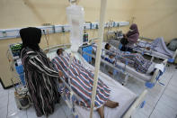 Relatives stand nearby as survivors of Saturday's deadly crush are treated at a hospital in Malang, East Java, Indonesia, Monday Oct. 3, 2022. Police firing tear gas at Saturday night's match between host Arema FC of East Java's Malang city and Persebaya Surabaya in an attempt to stop violence triggered a disastrous crush of fans making a panicked, chaotic run for the exits, leaving a large number of people dead, most of them trampled upon or suffocated. (AP Photo/Achmad Ibrahim)