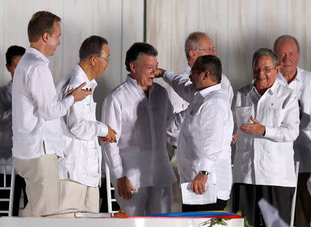 FILE PHOTO: Colombian President Juan Manuel Santos (3rd L) and Marxist FARC rebel leader Rodrigo Londono (2nd R), better known by the nom de guerre Timochenko, hug after signing an accord ending a half-century war that killed a quarter of a million people, in Cartagena, Colombia, September 26, 2016. REUTERS/John Vizcaino/File Photo