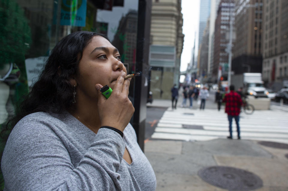 Eliana Miss Illi, General Manager of Weed World poses as she smokes a joint on 7th Avenue in Midtown New York City, March 31, 2021. - New York Governor Andrew Cuomo signed legislation legalizing recreational marijuana on March 31. 2021, with a large chunk of tax revenues from sales set to go to minority communities. New York joins 14 other US states and the District of Columbia in permitting cannabis after lawmakers in both state chambers, where Cuomo's Democratic Party holds strong majorities, backed the bill on March 30. (Photo by Kena Betancur / AFP) (Photo by KENA BETANCUR/AFP via Getty Images)