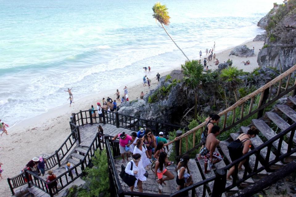 In this Jan. 4, 2013, photograph, a line of people leave the swimming beach next to the Mayan ruins in Tulum, Mexico. Tulum may be best-known for its ancient Mayan ruins, which attract a steady stream of day-trippers, cruise passengers and tour buses. The complex of crumbling structures here is smaller and less impressive than some other Mayan sites like Chichen Itza, but its location atop seaside cliffs is one of the most scenic ruin sites on the Yucatan. (AP Photo/Manuel Valdes)