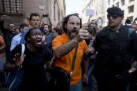 <p>Demonstrators react as they try to stop the car carrying Xavier Puig, a senior at the Department of External Affairs, Institutional Relations and Transparency of the Catalan Government office, after he was arrested by Guardia Civil officers in Barcelona, Spain, Wednesday, Sept. 20, 2017. (Photo: Emilio Morenatti/AP) </p>