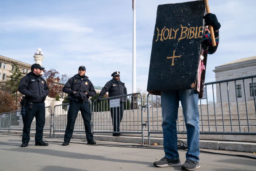 WASHINGTON, DC - DECEMBER 05: A person wearing a bible costume stands in front of the Supreme Court as protesters gather in front of the Supreme Court of the United States on Monday, Dec. 5, 2022 in Washington, DC. The High Court heard oral arguments in a case involving a suit filed by Lorie Smith, owner of 303 Creative, a website design company in Colorado who refused to create websites for same-sex weddings despite a state anti-discrimination law. (Kent Nishimura / Los Angeles Times)