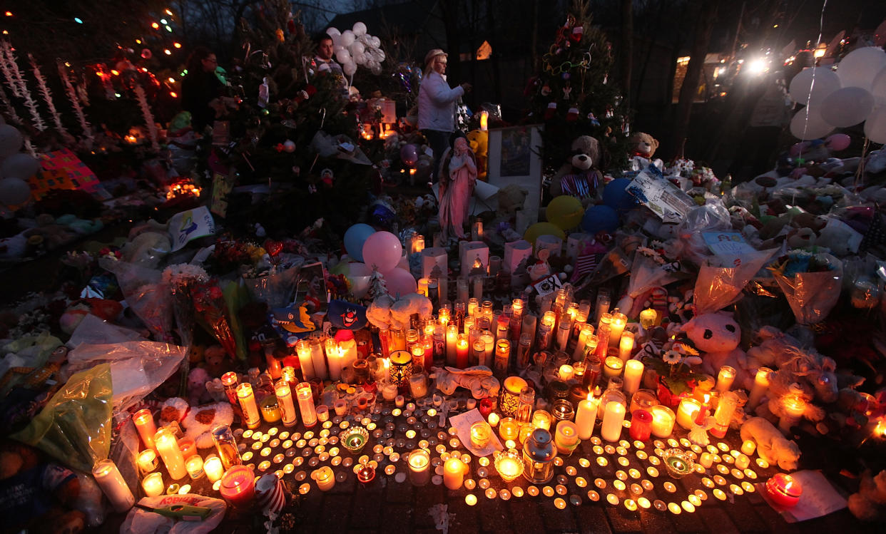 Candles are lit among mementos at a memorial for victims of the mass shooting at Sandy Hook Elementary School