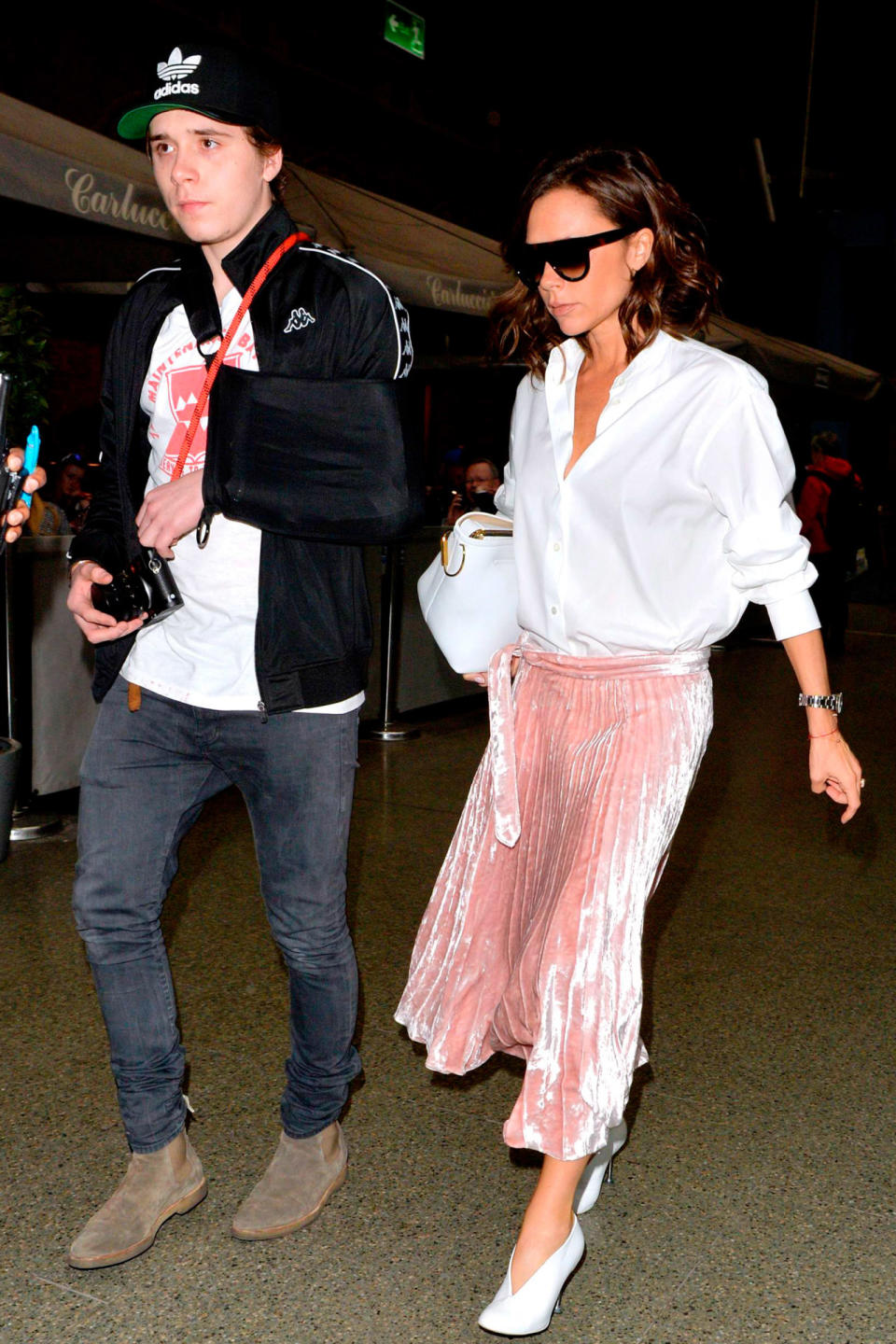 <p><strong>11 March</strong> Victoria Beckham wore her trademark pleated skirt with a white shirt and heels her while son Brooklyn kept it more casual as the two arrived back in London after a trip to Paris.</p>